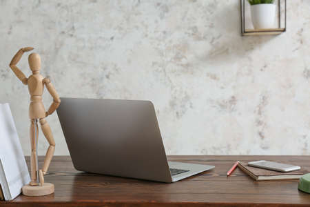 Modern laptop and mobile phone at workplace in roomの写真素材