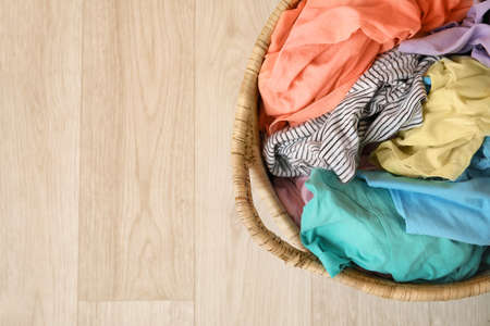 Wicker basket with laundry on floorの写真素材