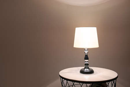 Glowing lamp on table in eveningの写真素材