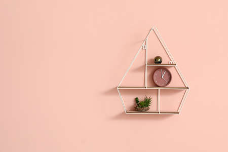 Stylish shelf with decor on color background