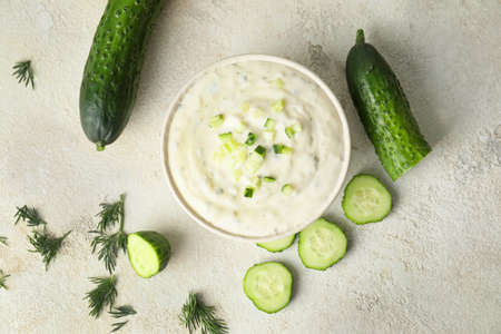 Delicious yogurt sauce with cucumber in bowl on white backgroundの写真素材