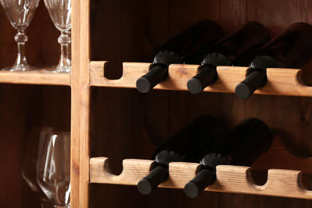 Bottles of wine and glasses in cellarの写真素材