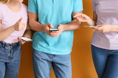 People with mobile phones on color background