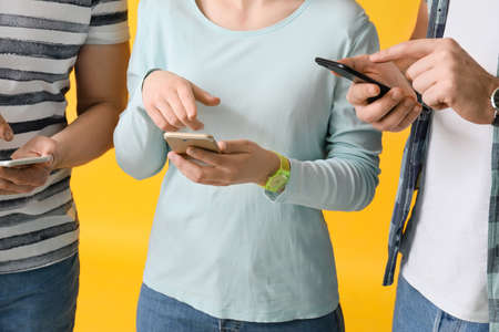 People with mobile phones on color backgroundの写真素材