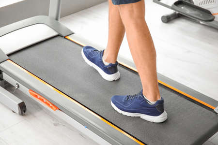 Young man training on treadmill in gymの写真素材