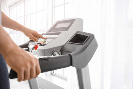 Young man training on treadmill in gym