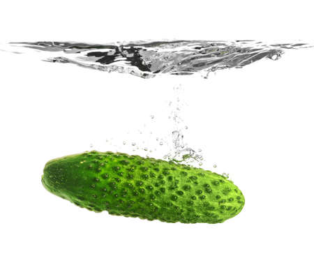 Falling of fresh cucumber into water against white backgroundの写真素材