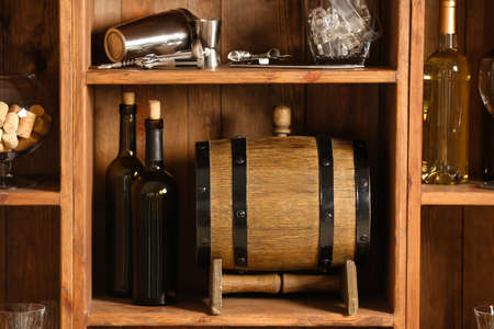 Barrel and bottles of wine on shelf in cellarの写真素材