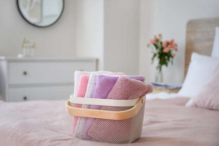 Basket with clean laundry on bedの写真素材