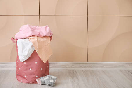 Basket with laundry on floor near wallの写真素材