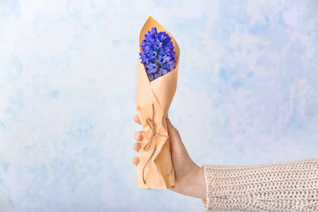 Female hand with beautiful hyacinth flowers on light backgroundの写真素材