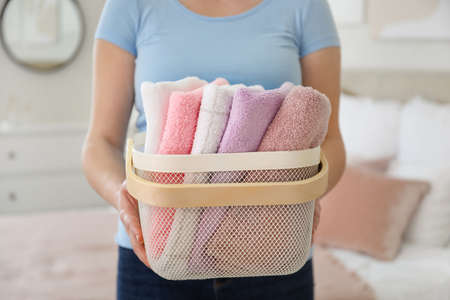 Woman with basket of laundry in roomの写真素材