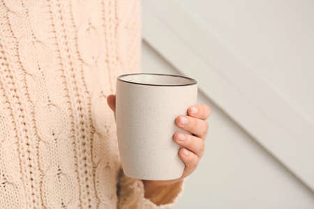 Woman with cup of tea on gray background, closeupの写真素材