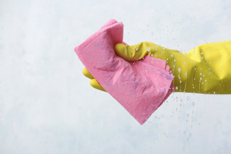 Housewife cleaning window at home
