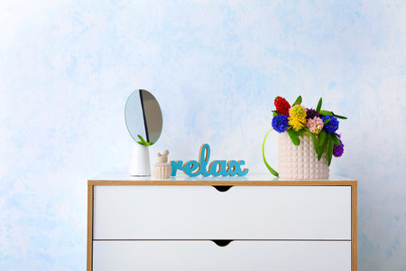 Vase with beautiful hyacinth flowers on chest of drawersの写真素材