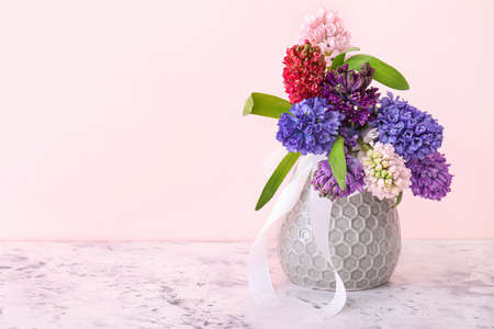 Vase with beautiful hyacinth flowers on color backgroundの写真素材