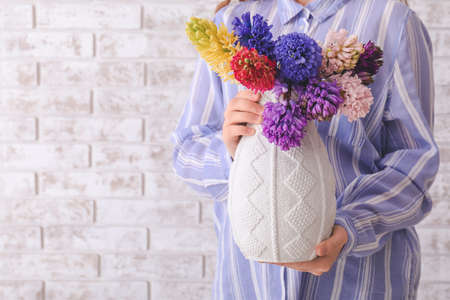 Woman with beautiful hyacinth flowers on brick background, closeupの写真素材