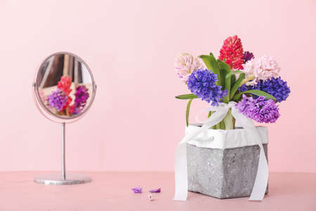 Box with beautiful hyacinth flowers on table against color backgroundの写真素材