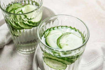 Glasses of infused cucumber water on light backgroundの写真素材