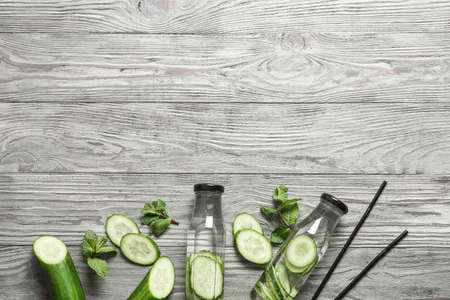 Bottles of infused cucumber water on wooden backgroundの写真素材