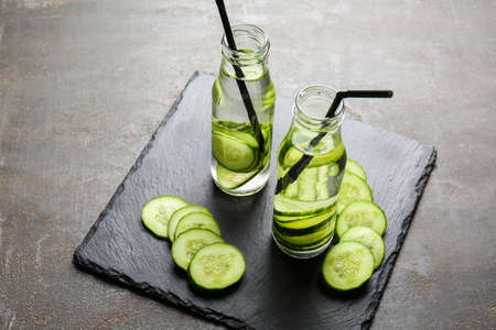 Bottles of infused cucumber water on dark backgroundの写真素材