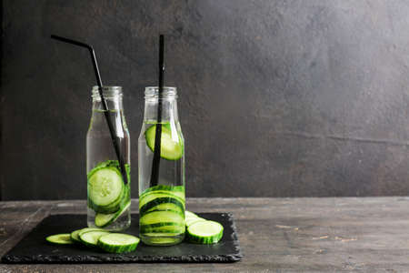 Bottles of infused cucumber water on dark backgroundの写真素材