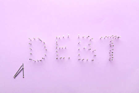 Word DEBT made of nails on color backgroundの写真素材