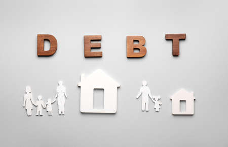 Figures of houses, family and word DEBT on gray backgroundの写真素材