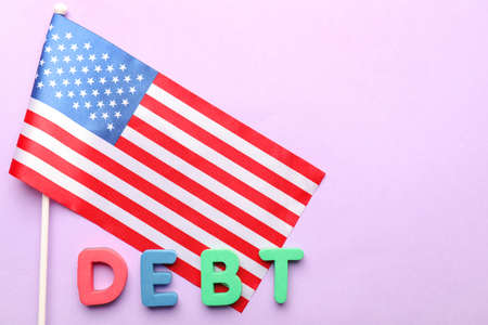 Word DEBT with national flag of USA on color backgroundの写真素材