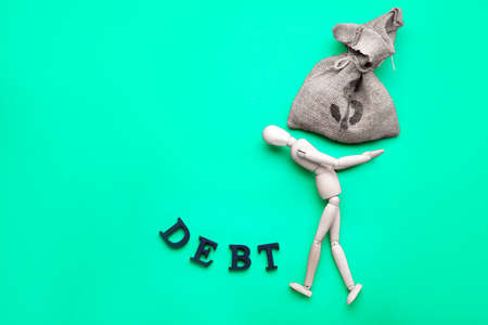 Mannequin, bag with money and word DEBT on color backgroundの写真素材