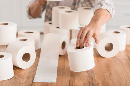 Mature man with heap of toilet paper at home.