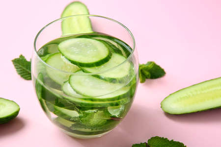 Glass of cucumber infused water on color backgroundの写真素材