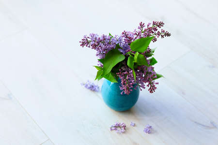 Vase with beautiful lilac flowers on floor in roomの写真素材
