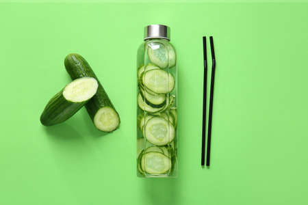 Bottle of cucumber infused water on color backgroundの写真素材