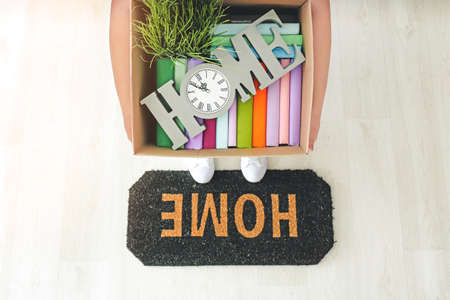 Person with belongings in box standing on door mat, top viewの写真素材