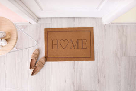 Door mat with shoes in hallwayの写真素材
