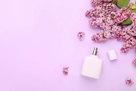 Beautiful lilac flowers and perfume on color backgroundの写真素材