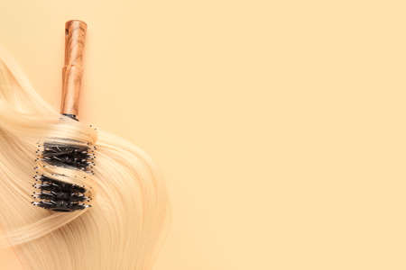 Long blonde hair and brush on color backgroundの写真素材