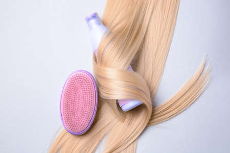 Bottle of shampoo for blonde hair and brush on light backgroundの写真素材
