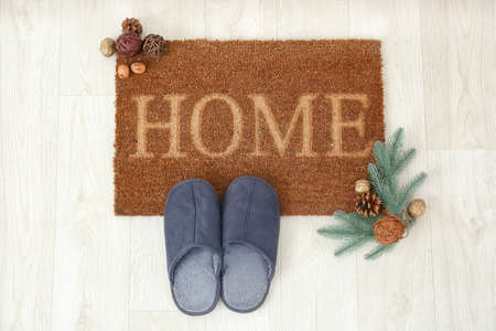 Door mat, Christmas decor and slippers on floorの写真素材