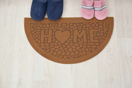 Door mat and slippers on floorの写真素材