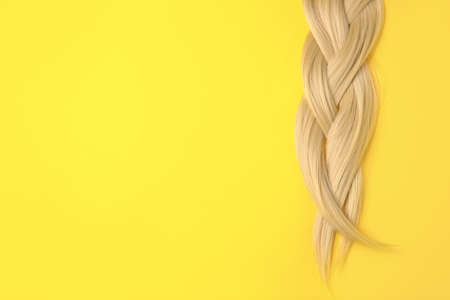 Beautiful braided blonde hair on color backgroundの写真素材