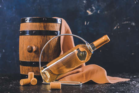 Holder with bottle of wine and barrel on dark backgroundの写真素材