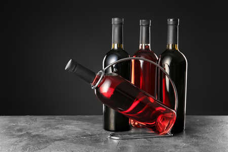 Holder with bottles of wine on dark backgroundの写真素材