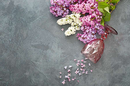 Bouquet of beautiful lilac flowers and glass on tableの写真素材