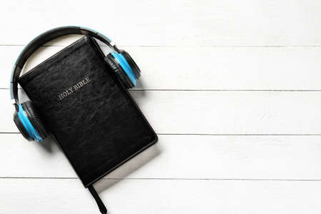 Holy Bible and headphones on white wooden backgroundの写真素材
