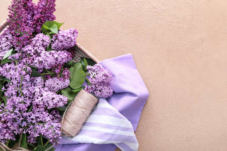 Wicker tray with beautiful lilac flowers on tableの写真素材