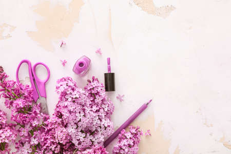 Beautiful lilac flowers, stationery and cosmetics on tableの写真素材