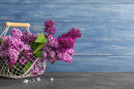 Bouquet of beautiful lilac flowers in basket on table