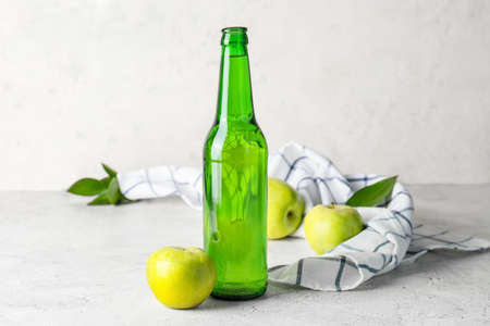 Bottle of apple cider on light background